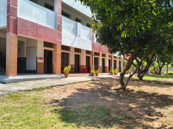 Mango Woods School classrooms opening onto a shaded, tree-filled campus